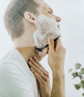 Man using a shaving cream that numbs the skin.